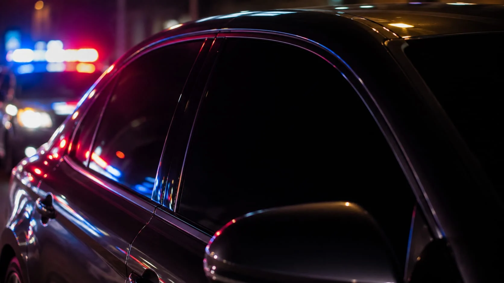 405-Freeway- - DUI Lawyer Orange County - DUI Lawyer Orange County Extremely dark tinted car window at night reflecting police lights in California